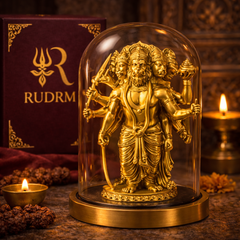 Golden statue of Lord Hanuman with multiple heads and arms under a glass dome, placed next to a 'Rudrm' branded box, with a lit diya and rudraksha beads in the background.